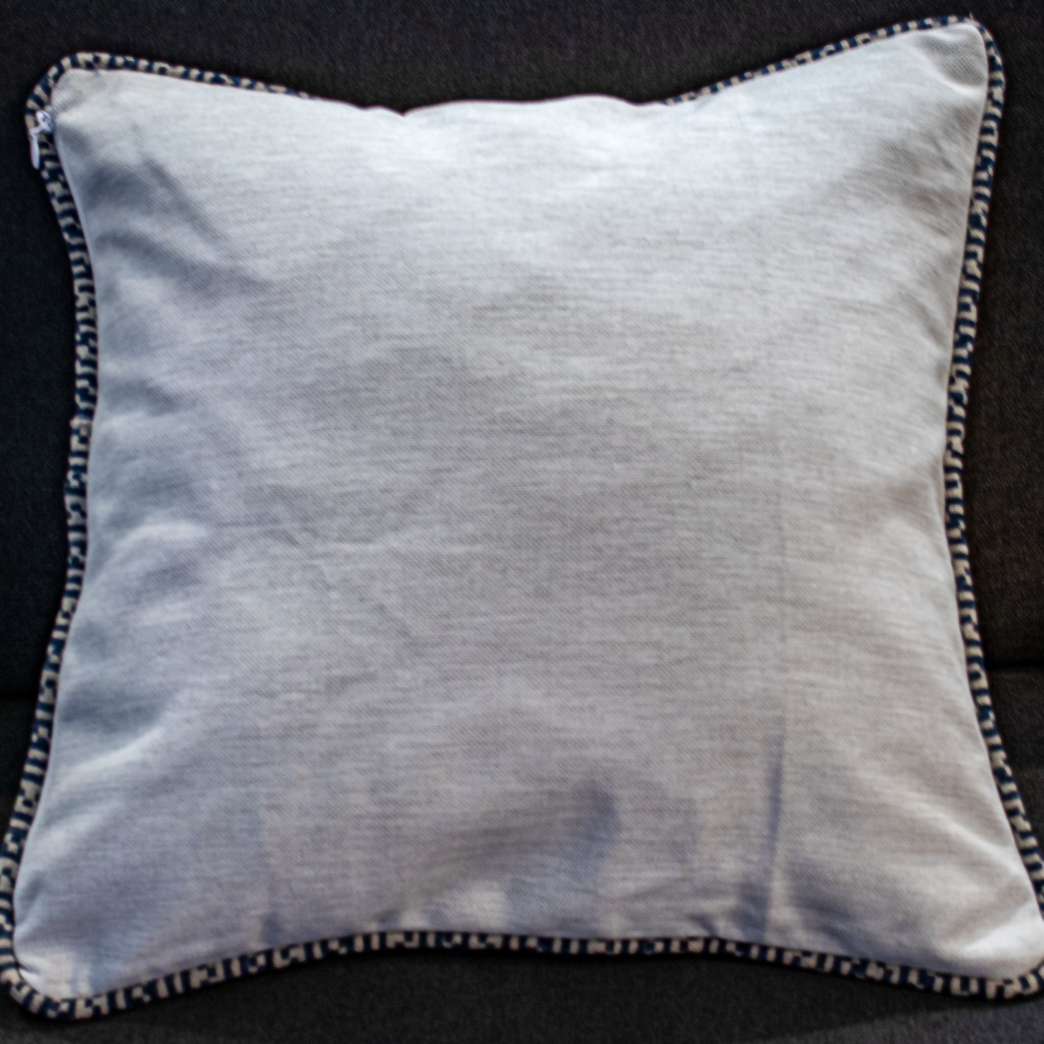 Sleek cream pillow cover with blue geometric piping reversible with gold / yellow bloom fabric on the other side.