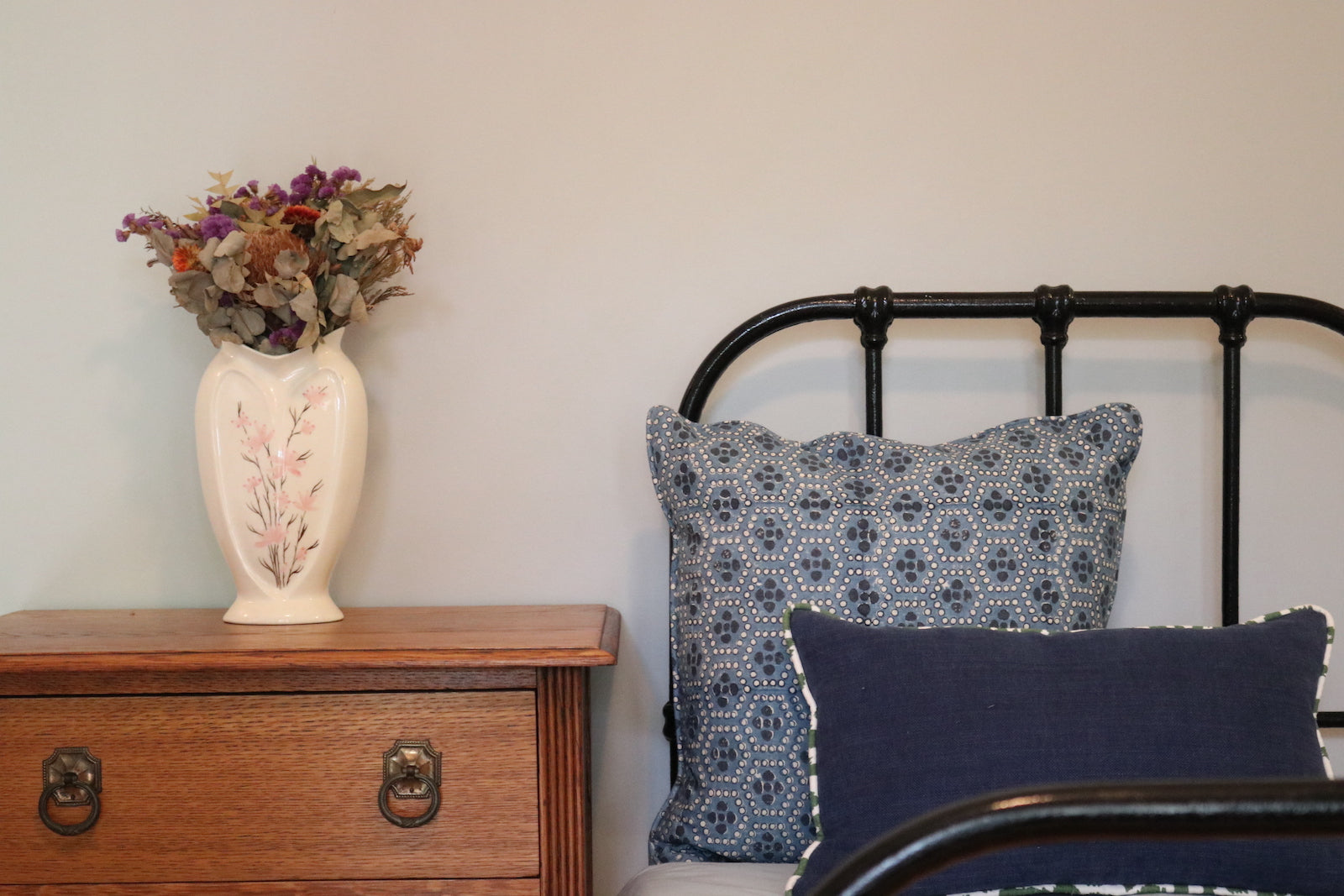 Ash Block Printing - Mewari - Denim 55cm Scatter Cushion in situ on a wrought iron bed.