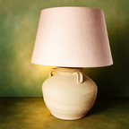 wabi - sabi Table lamp with a pink lampshade on a textured green surface