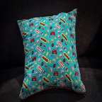 Disney cars cushion with teal side featuring Lightning McQueen and reversible red and white checkered pattern.