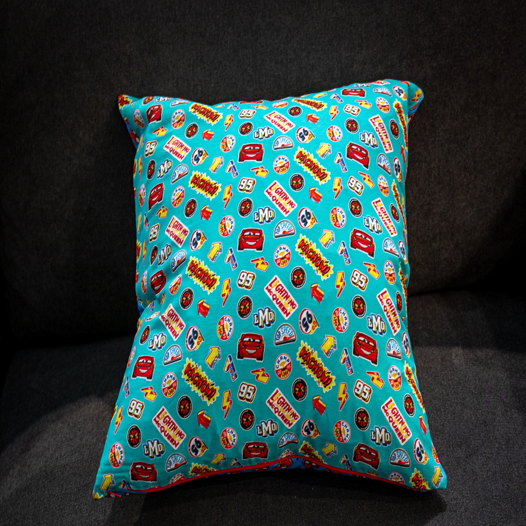 Reversible Disney Pixar Cars cushion with a playful all-over Lightning McQueen and racing badge print. A colorful 50 x 50 cm pillow that adds fun and character to children’s bedrooms, playrooms, or themed interiors. Luxe & Humble exclusive.
