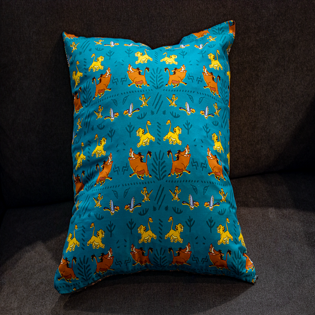 Playful turquoise Lion King print pillow with Simba, Timon & Pumbaa – reversible cushion by Luxe & Humble