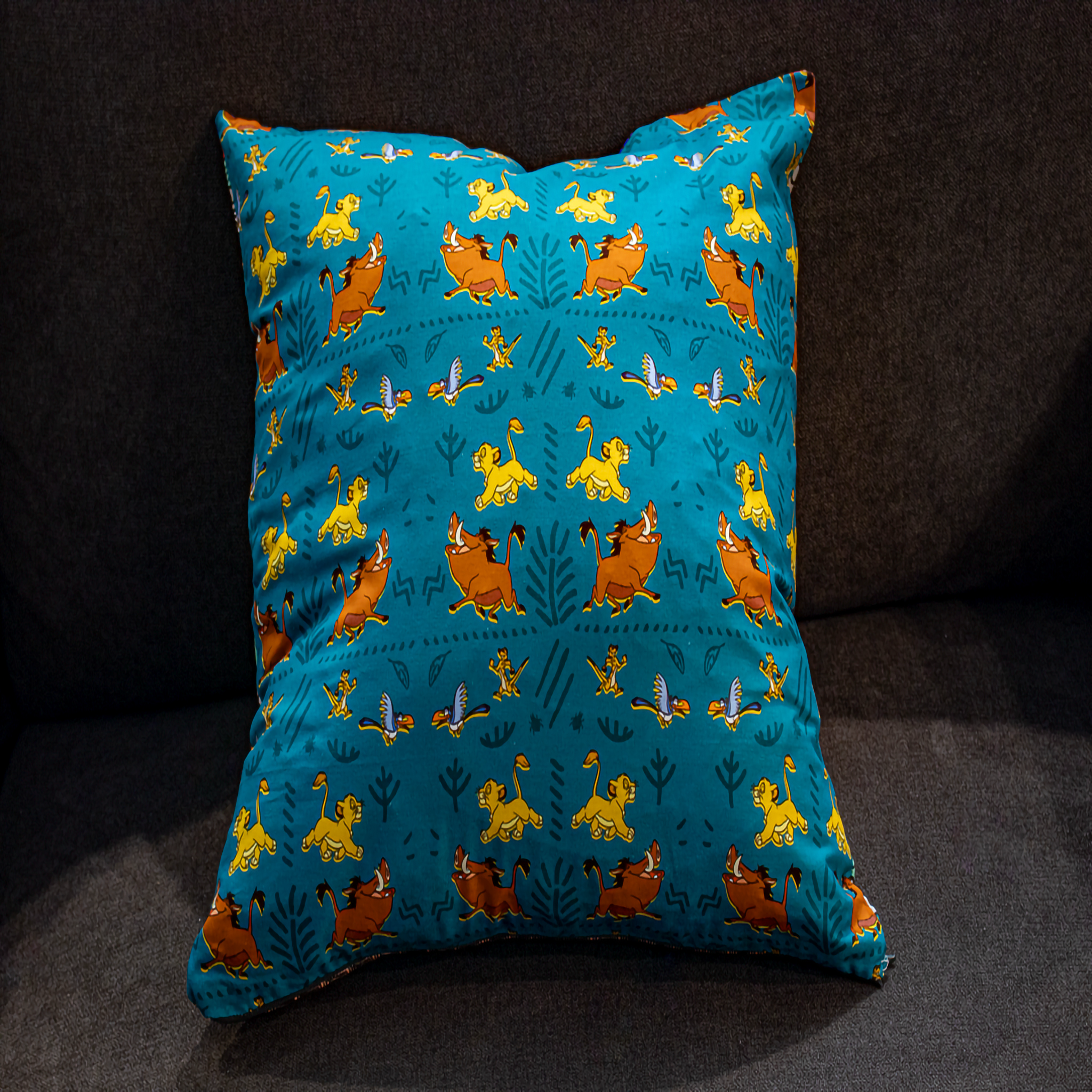 Playful turquoise Lion King print pillow with Simba, Timon & Pumbaa – reversible cushion by Luxe & Humble
