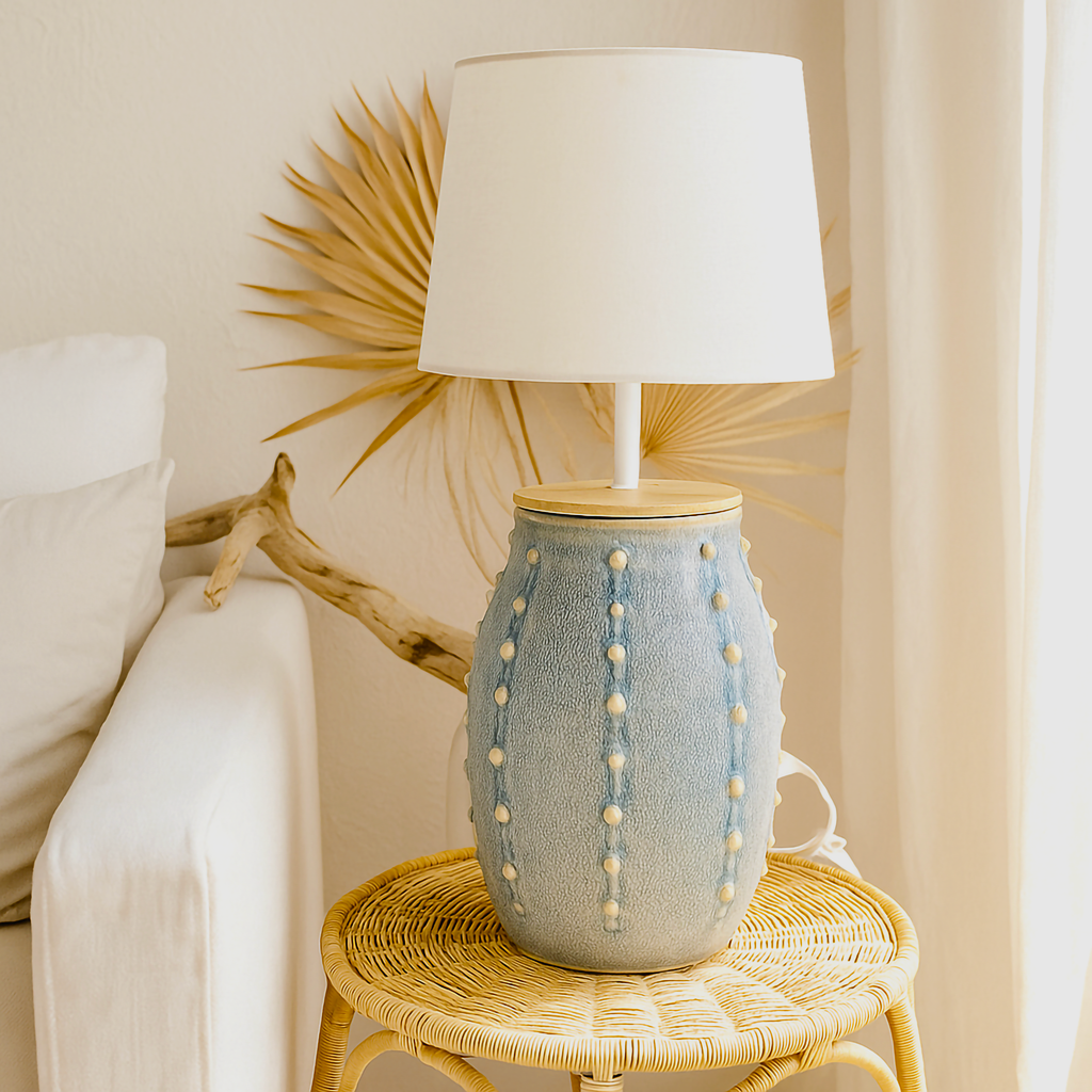 Handcrafted in Australia, the Coastal Clay Lamp Base by B.Bailey.Design.Co. features a soft blue ceramic glaze, timber top, and organic beaded texture. Styled in a bright coastal home with natural rattan and sunlight for a relaxed, Australian-made interior aesthetic.