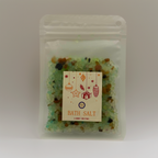 A Luxe & Humble Festive Forest Christmas Bath Salt in a clear resealable pouch filled with green and earthy mineral salts. The festive label features Christmas ornaments and gift illustrations. Photographed on a clean studio background, ideal for product listings and Australian Christmas gift shopping.