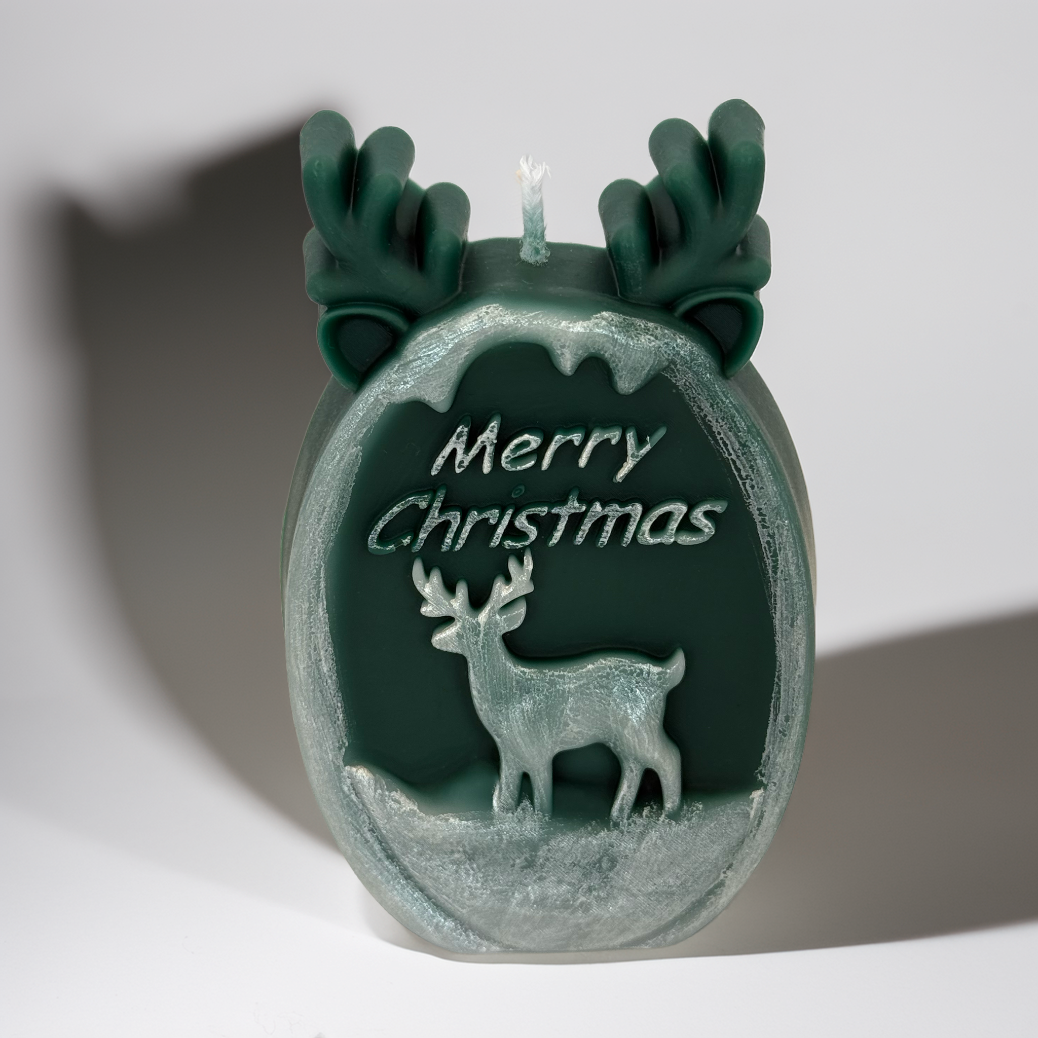 Green reindeer-shaped Christmas candle with antler details and “Merry Christmas” engraving, photographed on a clean studio background. A festive Australian décor piece perfect for Christmas gifting, home styling, and holiday displays.