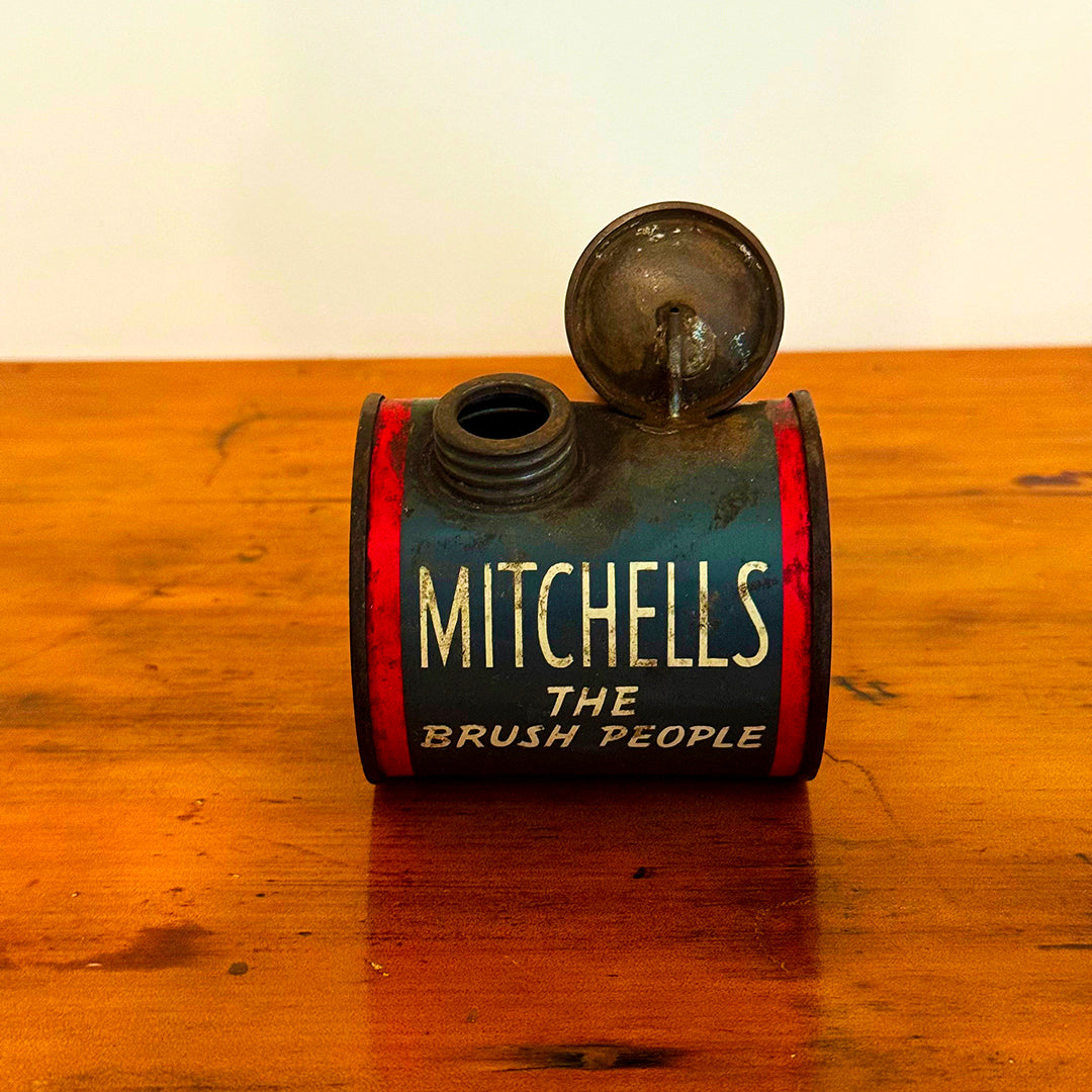 A close-up of a Vintage Mitchell’s Insect Spray canister in red and blue, marked with the iconic "Mitchell’s The Brush People" branding. The canister shows natural signs of wear, showcasing its vintage charm.