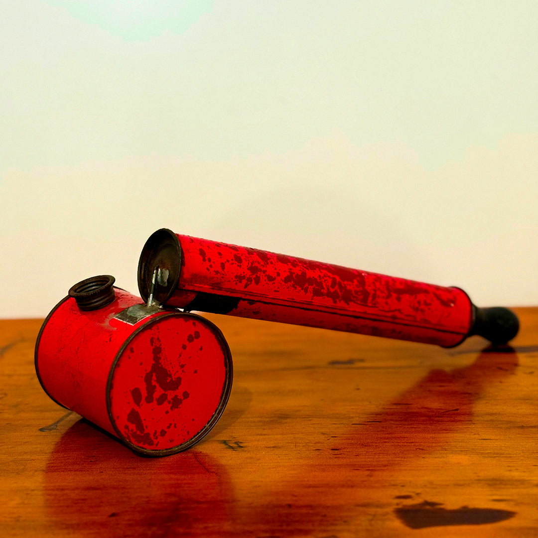 A close-up of a Vintage Red Insect Spray Can with a hand pump, featuring a distressed red finish. The can shows signs of wear, making it a unique and nostalgic collectible for any vintage collection.