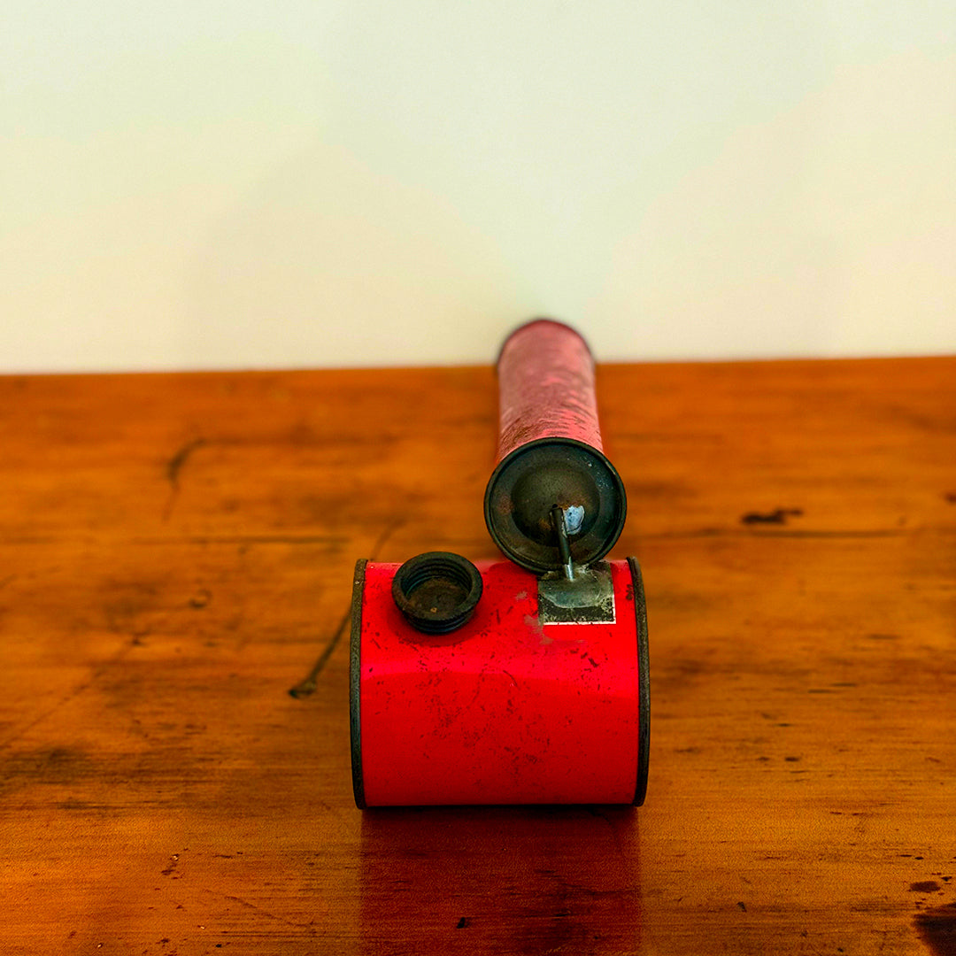 A close-up of a Vintage Red Insect Spray Can with a hand pump, featuring a distressed red finish. The can shows signs of wear, making it a unique and nostalgic collectible for any vintage collection.