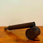 Vintage brown insect spray hand pump with a worn exterior and metal cap, displayed on a wooden surface showcasing its retro, rustic design.