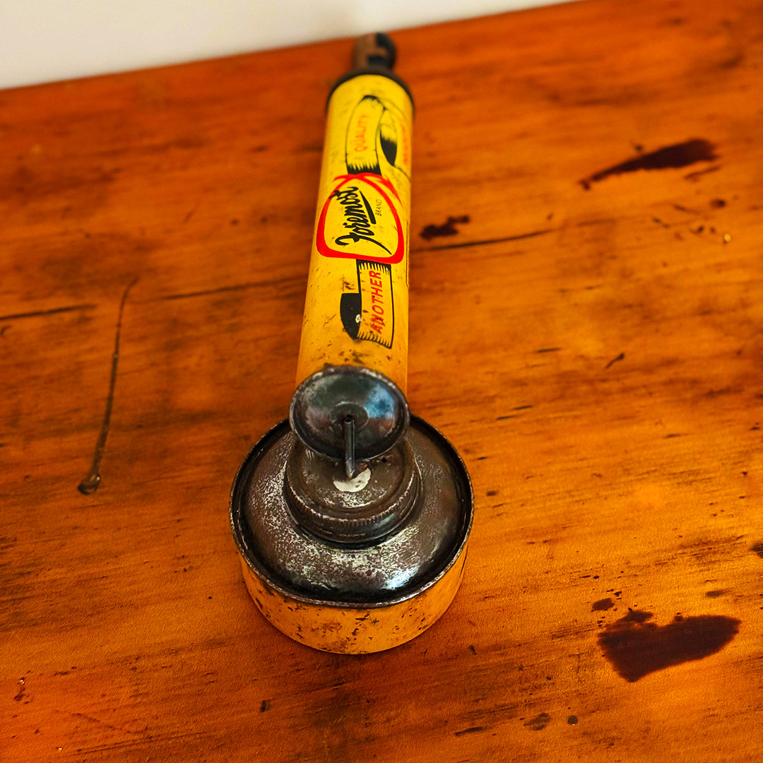 Vintage Insect Spray Hand Pump with red and worn surface, displaying classic mid-20th-century design, shown on a wooden surface.