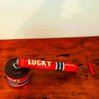 Vintage Lucky Sprayer with a red and blue design, showcasing a hand pump insecticide dispenser on a wooden surface.