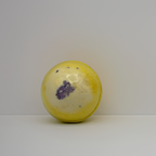 A yellow and cream bath bomb with a purple lavender centre, photographed with warm festive lighting. A handcrafted Australian bath bomb from Luxe & Humble, perfect for relaxation, gifting and Christmas pamper sets.