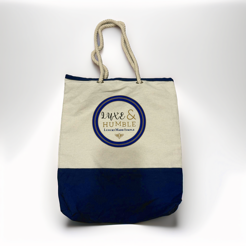 A high-quality product photo of the Luxe & Humble canvas tote bag displayed upright on a clean white background. The bag features a natural canvas upper, navy base, thick rope handles, and the signature Luxe & Humble round logo. Crisp, clear and ideal for Australian shoppers wanting a detailed view of the bag’s design and craftsmanship.