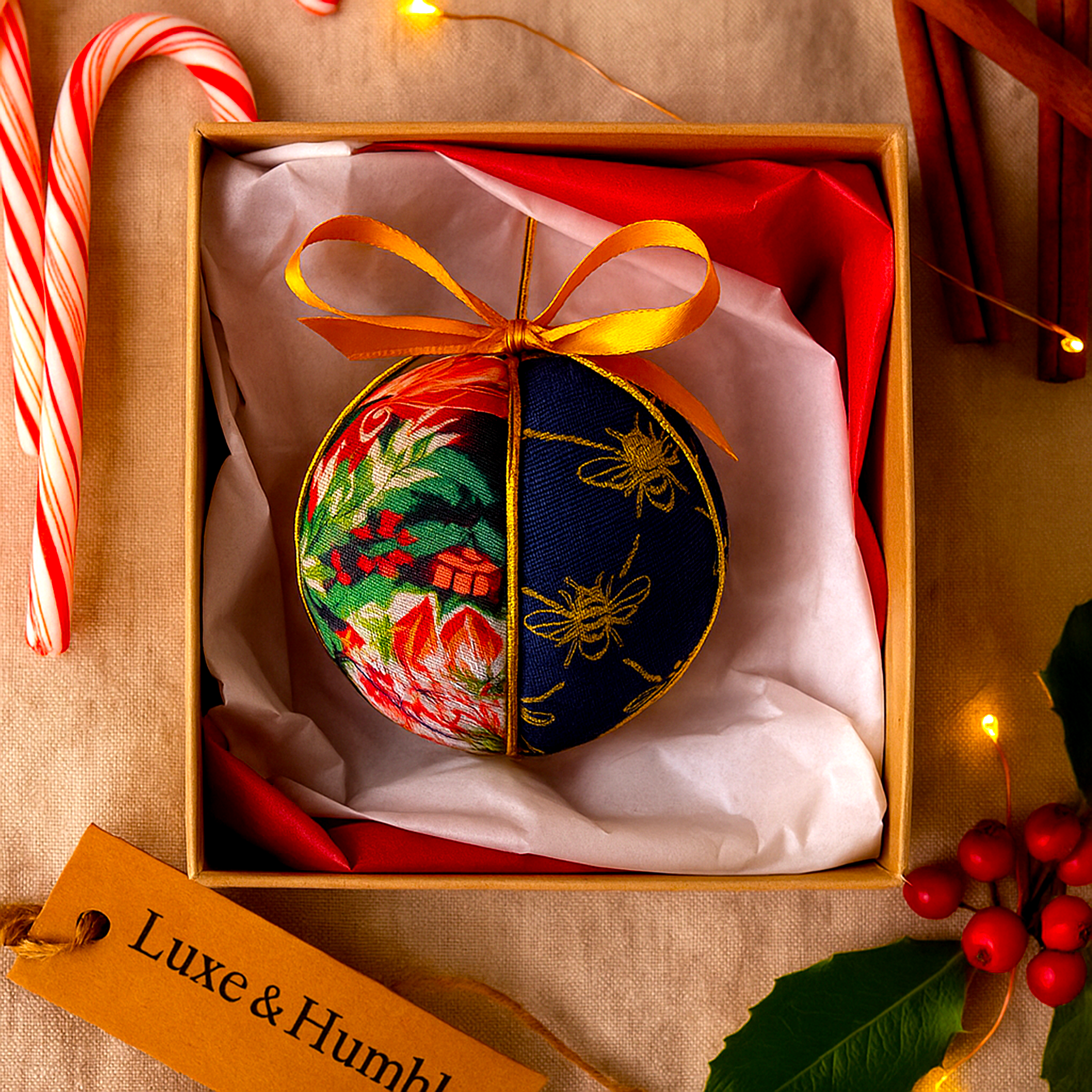 Handmade Luxe & Humble navy and gold Christmas bauble crafted in Australia, featuring festive floral fabric with gold detailing and a satin bow, presented in a gift box with red tissue paper and holiday accents for a classic Australian Christmas.