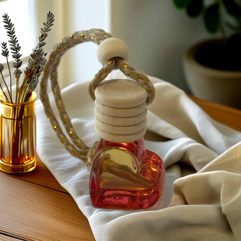 Red heart-shaped glass car diffuser with rustic rope top, infused with Coconut Cream fragrance by Luxe & Humble, styled in natural light.
