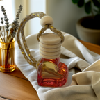 Red heart-shaped glass car diffuser with rustic rope top, infused with Coconut Cream fragrance by Luxe & Humble, styled in natural light.