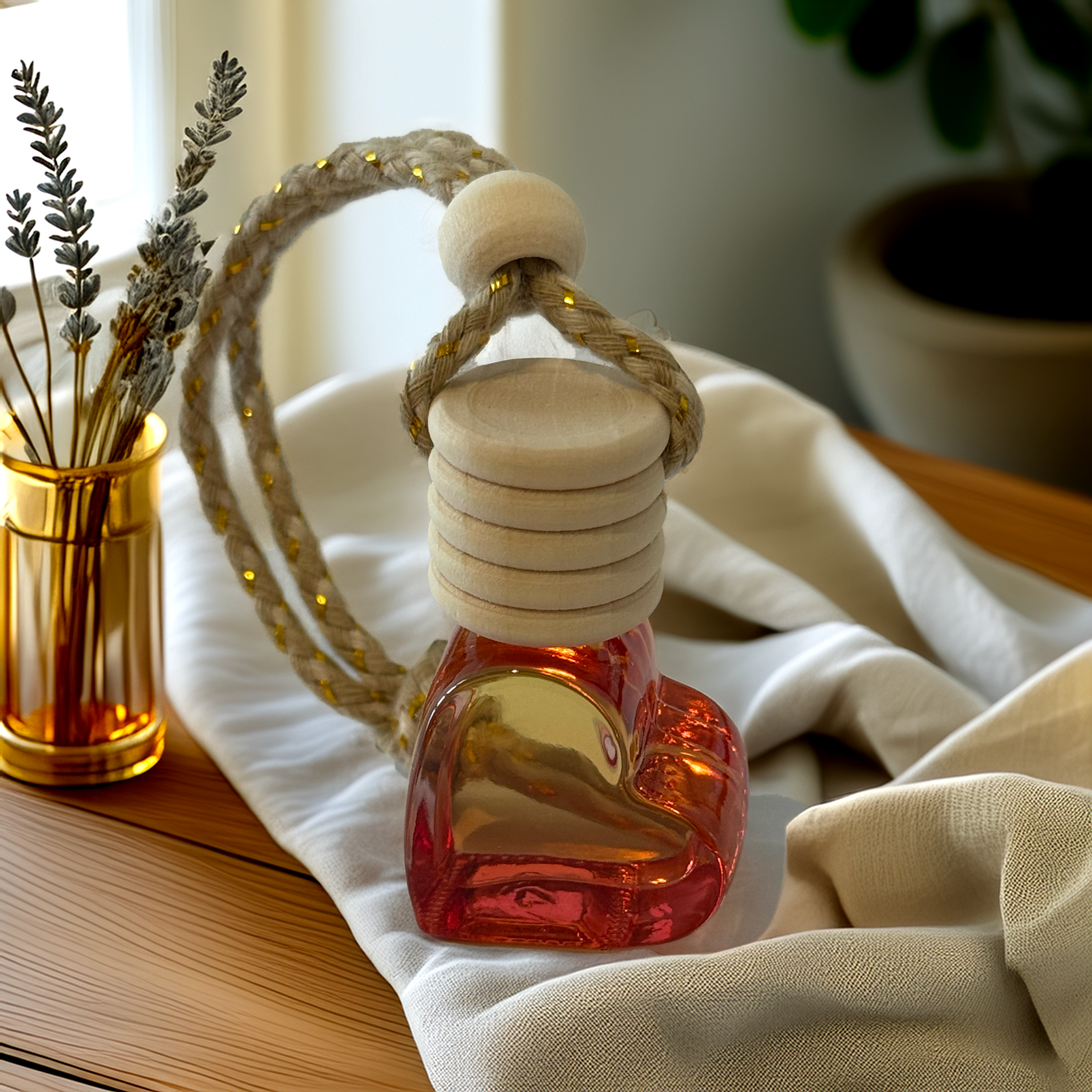 Red heart-shaped glass car diffuser with rustic rope top, infused with Coconut Cream fragrance by Luxe & Humble, styled in natural light.