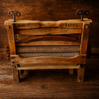 Close-up of an antique wooden clothes wringer by American Wringer Co., featuring iron handles, hand-crank gears, and worn textured rollers. Styled on rustic timber with a warm brown backdrop, this Luxe and Humble piece highlights authentic early laundry tools and vintage craftsmanship.