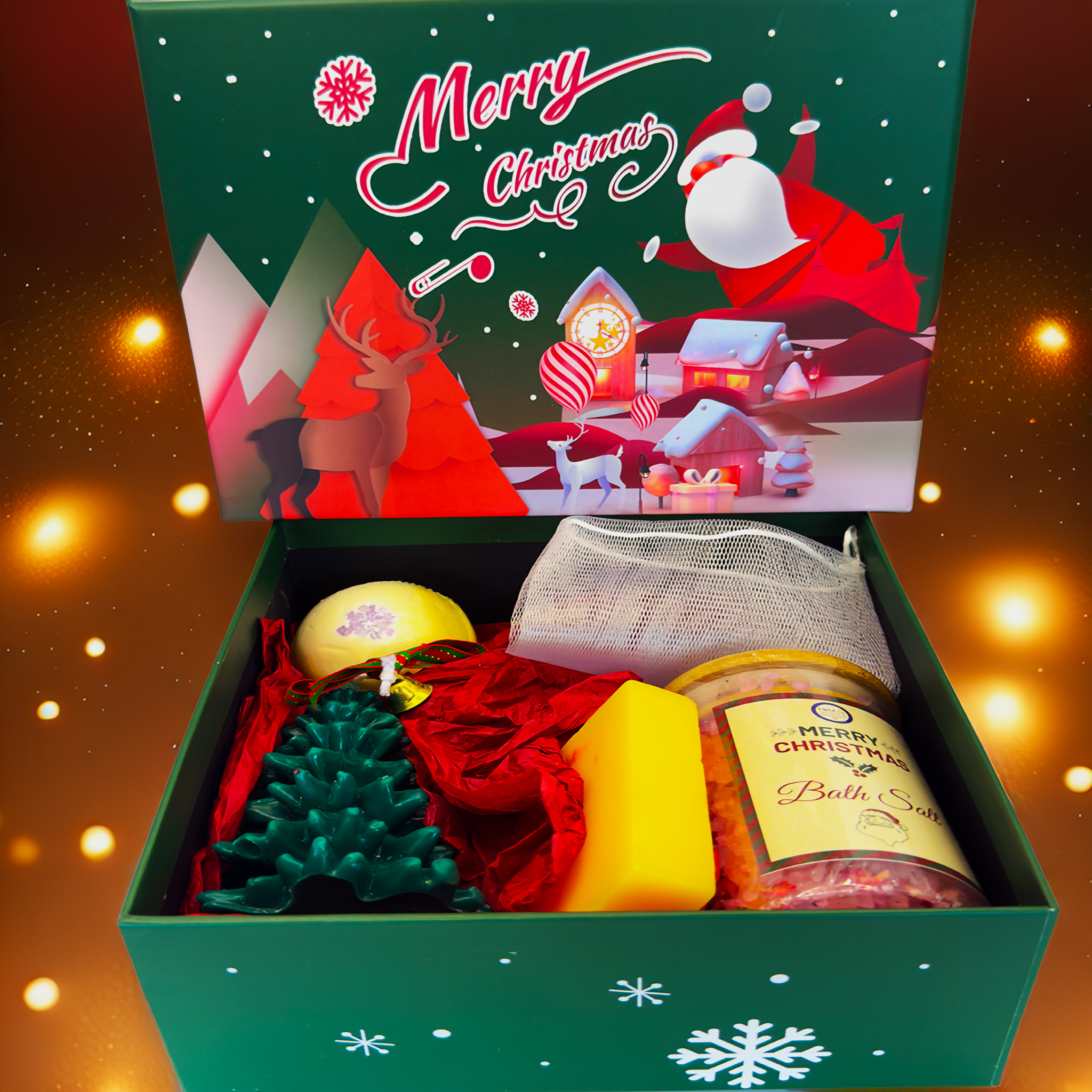 A Luxe & Humble Christmas gift set displayed in an illustrated green “Merry Christmas” box, containing a yellow bath bomb, green Christmas tree candle, yellow soap, mesh bag, and a jar of colourful bath salts. Styled with warm glowing festive lights, ideal for Australian Christmas gifting, wellness hampers and holiday self-care sets.