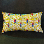 Rectangular decorative cushion by Luxe and Humble featuring an Australian native parrot in striking pink, blue, and red plumage, surrounded by yellow and pastel botanical flowers on a soft cream background. This designer cushion brings a vibrant, tropical Australian touch to interiors, ideal for styling sofas, beds, or accent chairs.