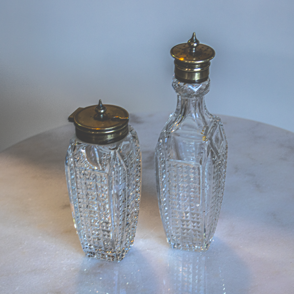 Cut glass and silver condiment bottles with silver lids