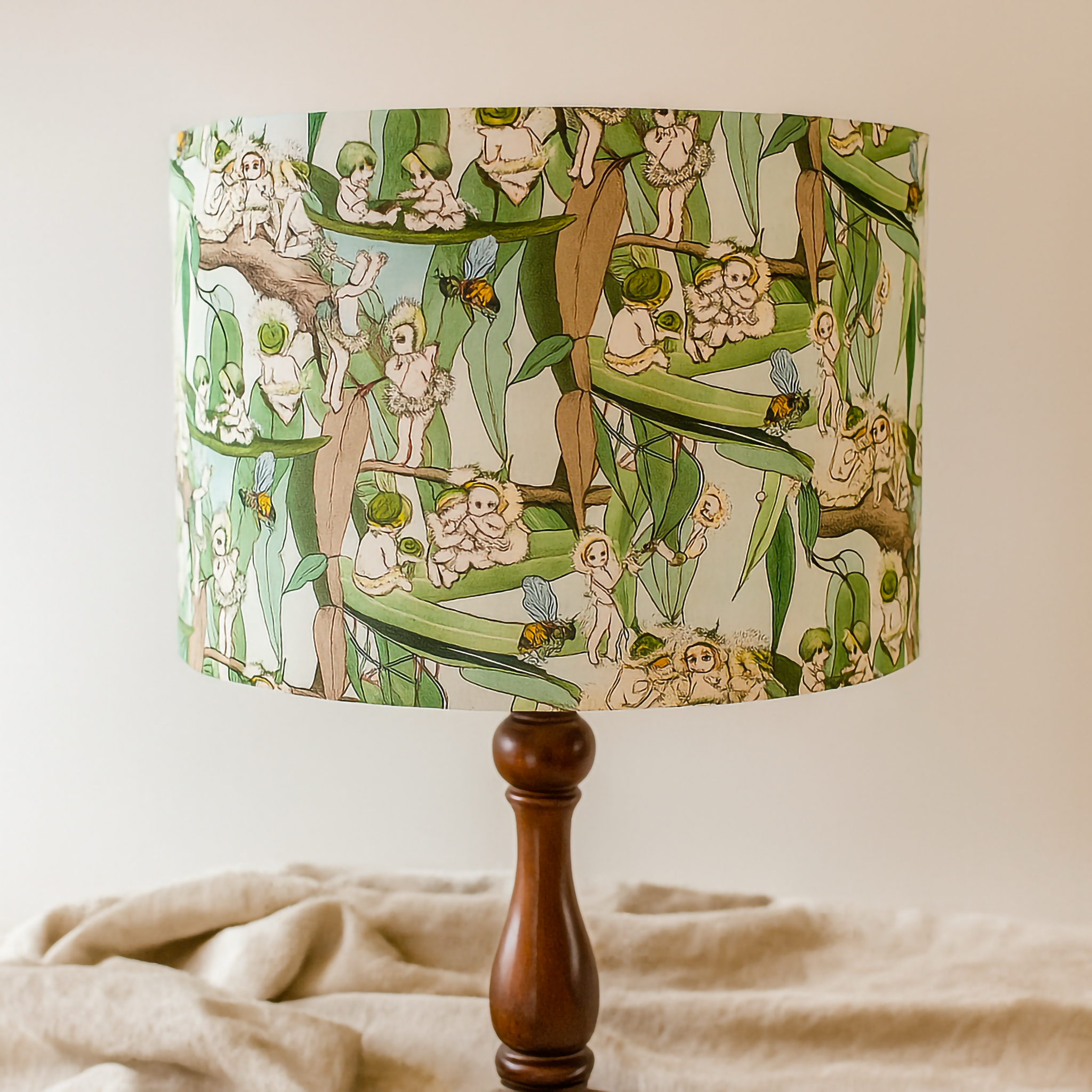Whimsical lampshade with illustrated botanical fairy pattern on wooden lamp base

Storybook-inspired lampshade featuring tiny bush folk and blossoms

Decorative fairy design lampshade styled with a wooden base

Playful botanical illustration lampshade for nursery or reading nook