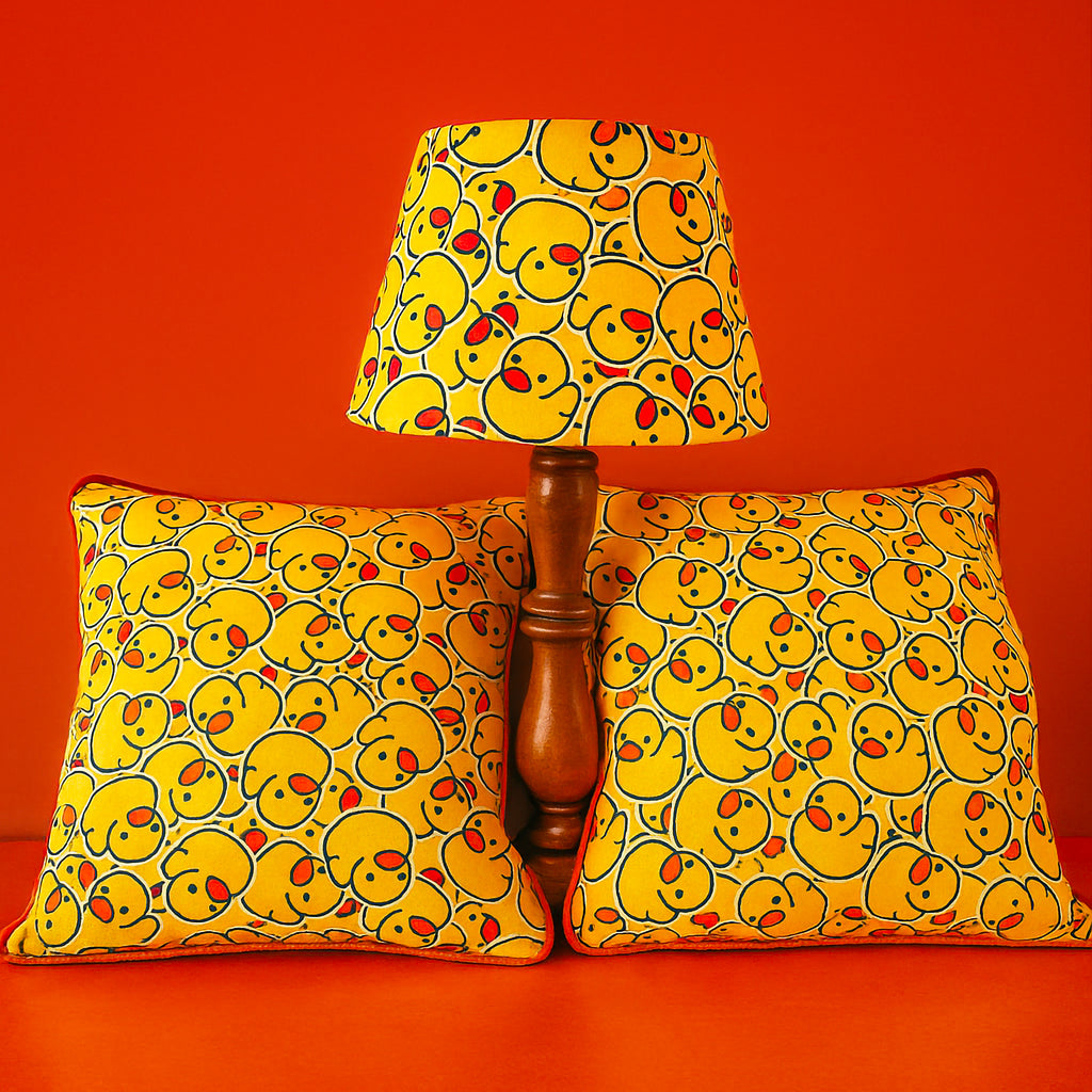 Duck print empire lampshade with matching 50 x 50 cm cushions styled on bright orange background

Playful yellow duck pattern lampshade and cushions with bold red-orange backdrop

Empire lampshade and bespoke cushions featuring cheeky duck print design for fun interiors

Vibrant duck print home decor set with lampshade and matching cushions on orange surface