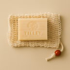 A handcrafted Purity Pouch exfoliating sisal soap bag paired with Tilley Goats Milk & Manuka Honey soap, styled on a neutral background to showcase its natural texture and eco-luxury appeal.