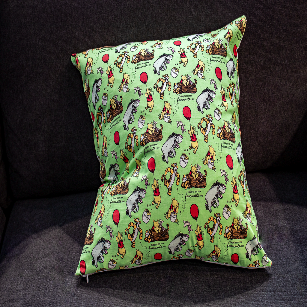 Winnie the Pooh reversible pillow featuring Pooh, Tigger, and Eeyore, with one side showcasing an inspirational quote and the other a playful balloon design, made from premium cotton fabric.