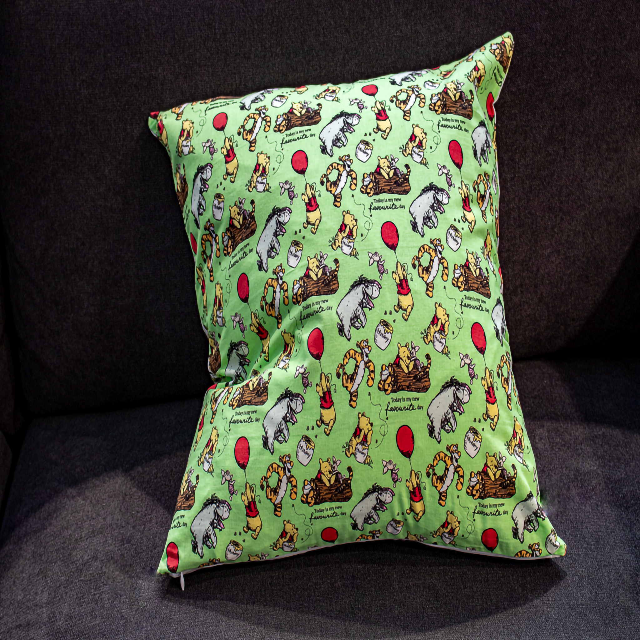 Winnie the Pooh reversible pillow featuring Pooh, Tigger, and Eeyore, with one side showcasing an inspirational quote and the other a playful balloon design, made from premium cotton fabric.