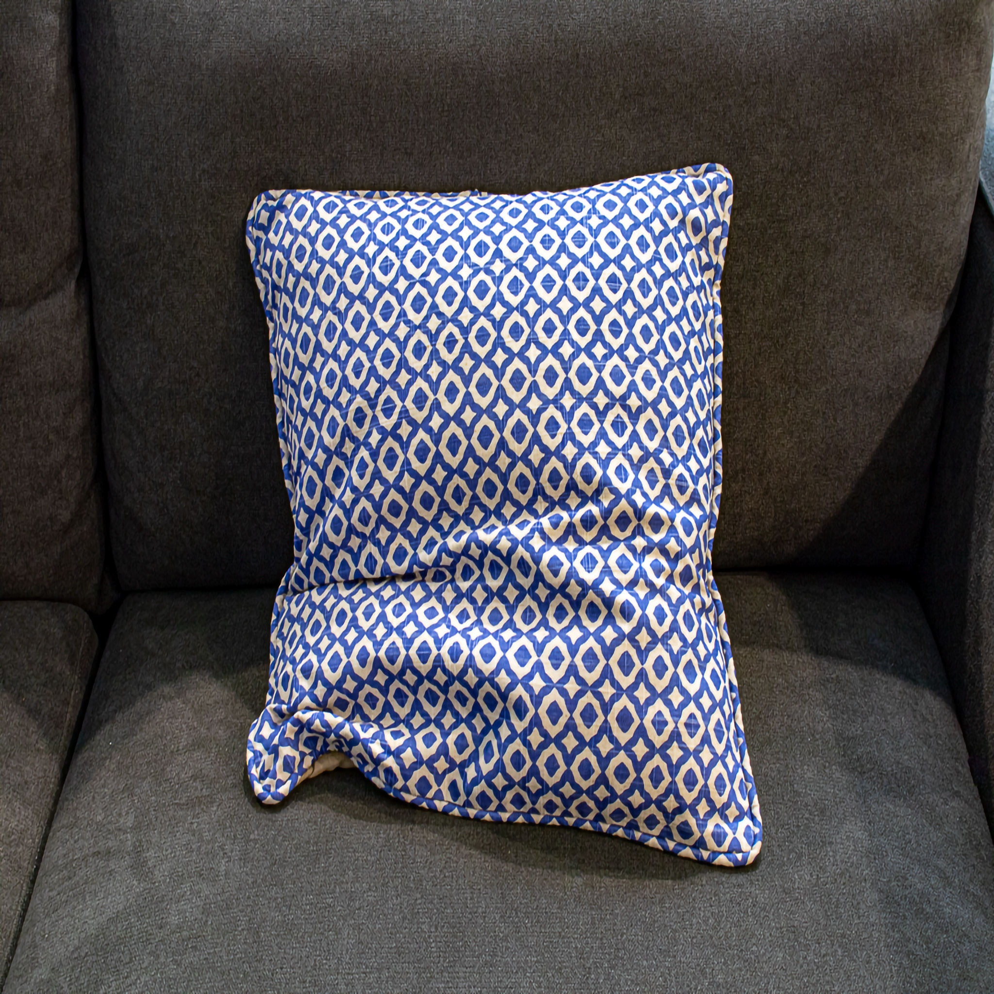 Reversible beige pillow cover with blue geometric piping, offering both a minimalist and stylish accent for your home décor.
