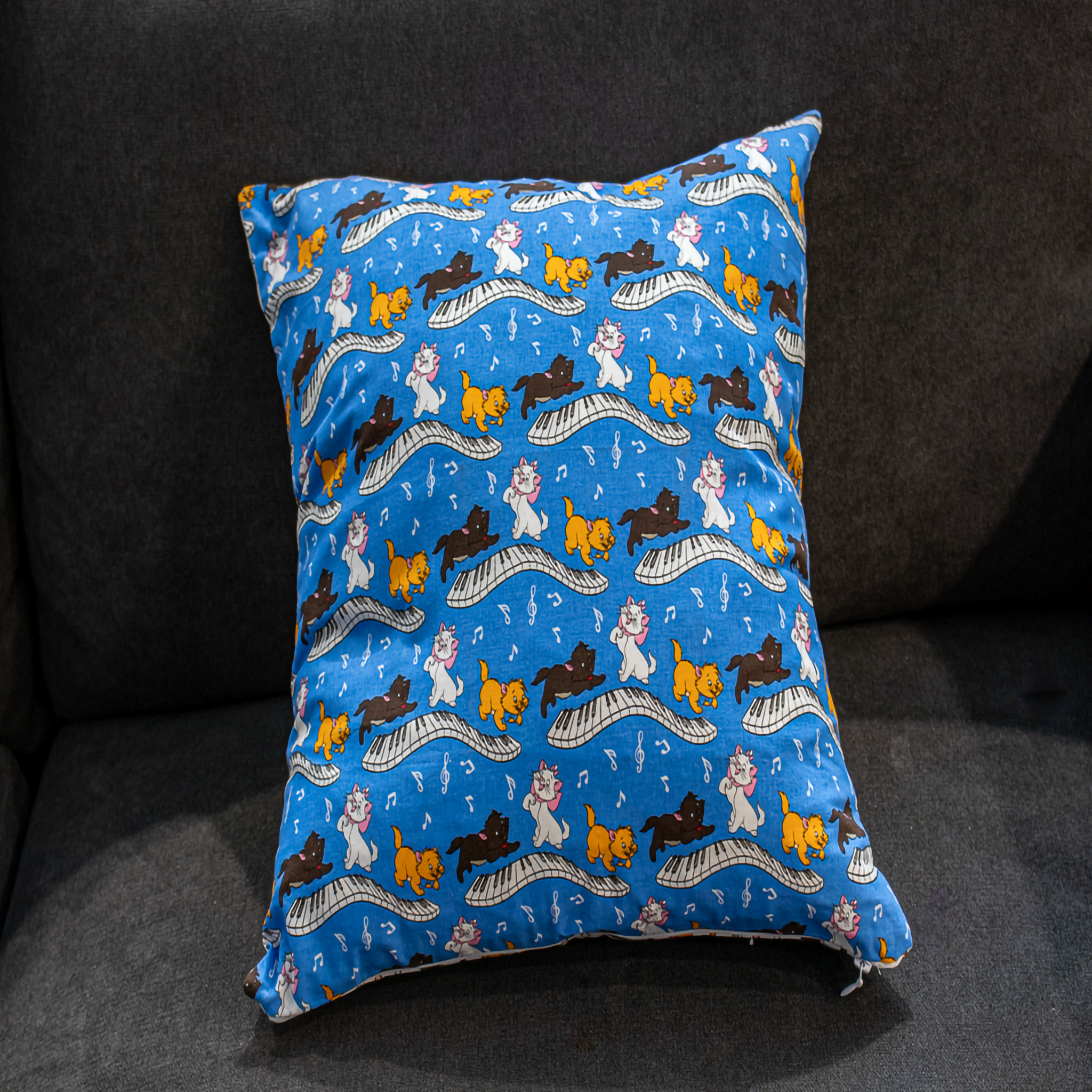 Disney cat pillow cover in blue with playful cats on a piano, featuring musical notes. A fun and whimsical accent for Disney lovers. reversible 
