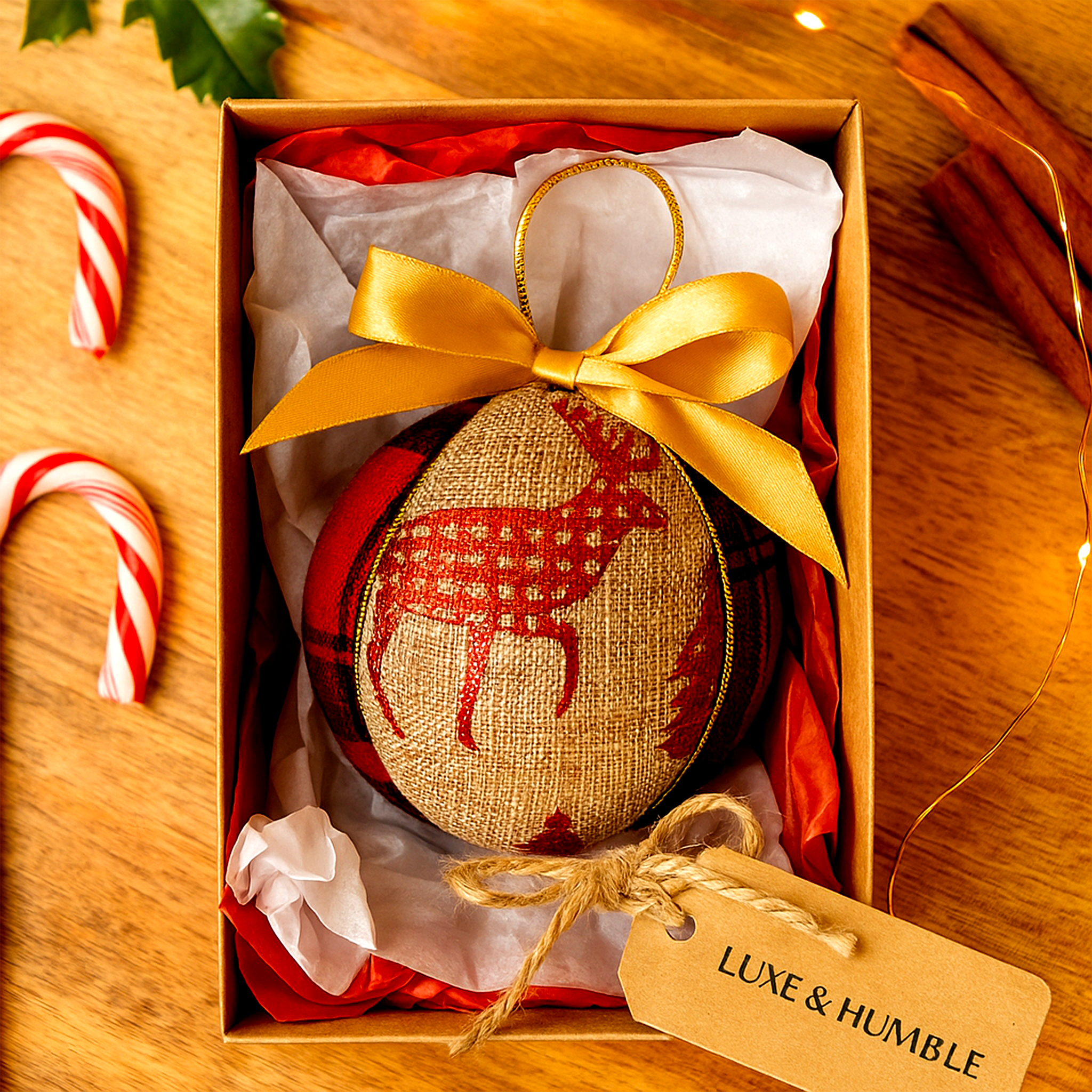 Handmade Luxe & Humble rustic Christmas bauble featuring red tartan and linen fabric with gold bow and reindeer motif in a festive gift box.