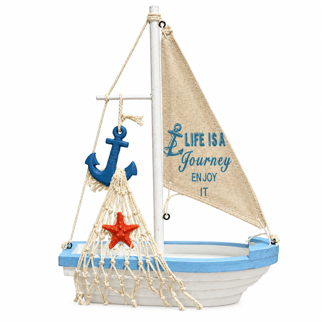 A decorative nautical sailboat ornament with a white hull, light blue trim, a beige burlap sail printed with the phrase 'Life is a Journey Enjoy It,' a blue anchor, a cream rope net, and a red starfish on a white background.