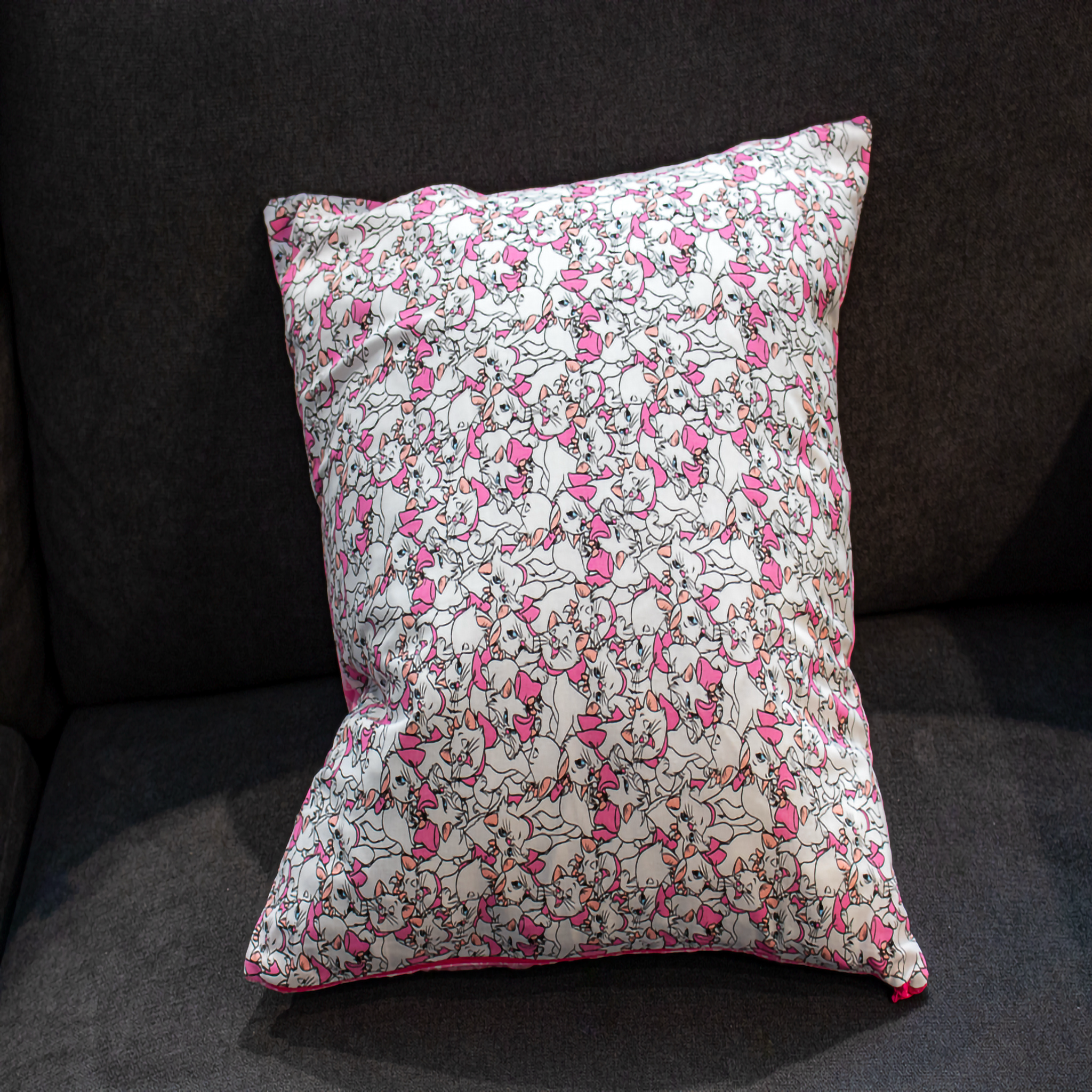 Disney cat-themed pillow cover in pink and white featuring a playful cat print, bringing a fun, magical touch to your décor. reversible 
