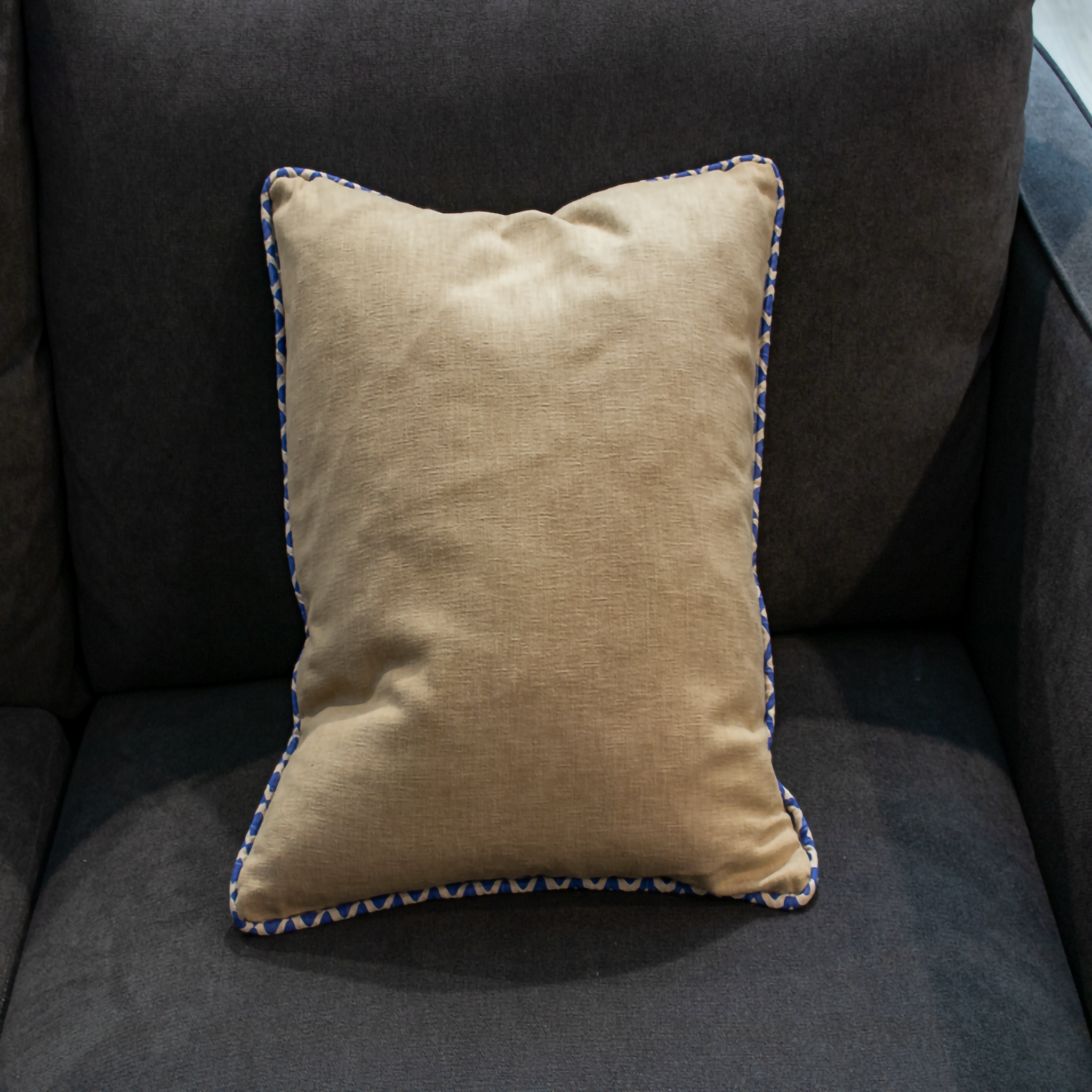 Beige pillow cover with blue geometric piping and blue geometric reverse side, offering an elegant touch to your home décor.