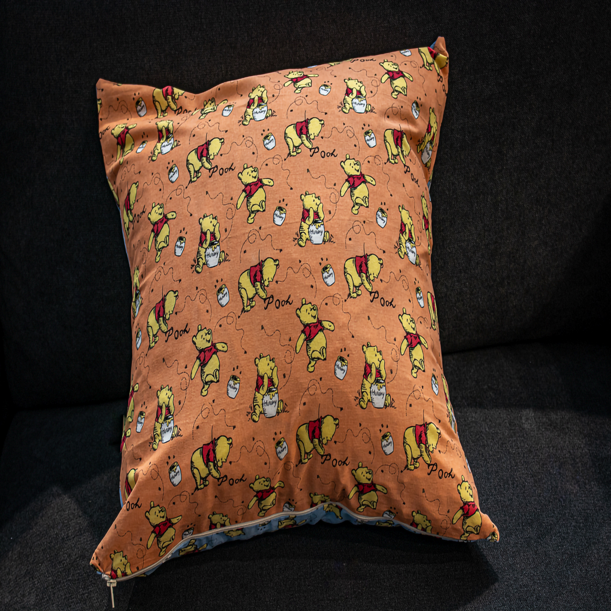 Winnie the Pooh with a honey pot on a bright orange background, featuring the word "Pooh" and playful designs, adding a fun, whimsical touch to your décor.