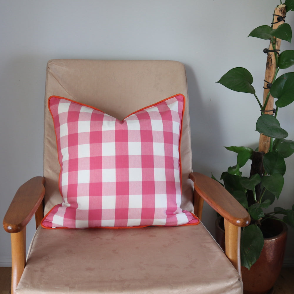 Pink Gingham Cushion with Orange Piping. 