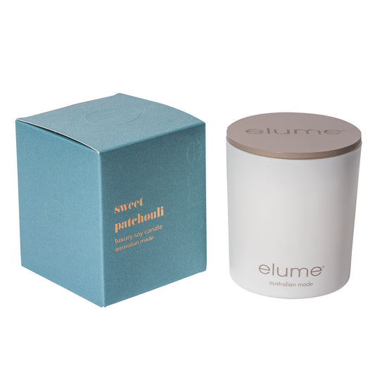 Elume Sweet Patchouli Soy Candle Box, sitting beside the Candle with its lid on.